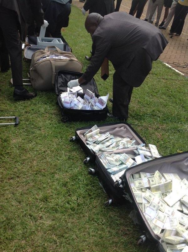 Nairobi police inspecting the bundles of fake note stacks found in suitcases
